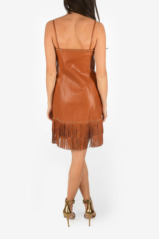 vestito in pelle e spaghetti strap con frange e borchie