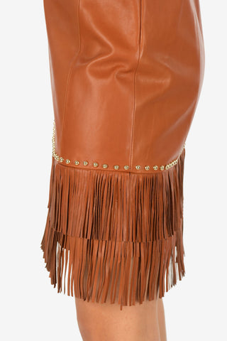 vestito in pelle e spaghetti strap con frange e borchie